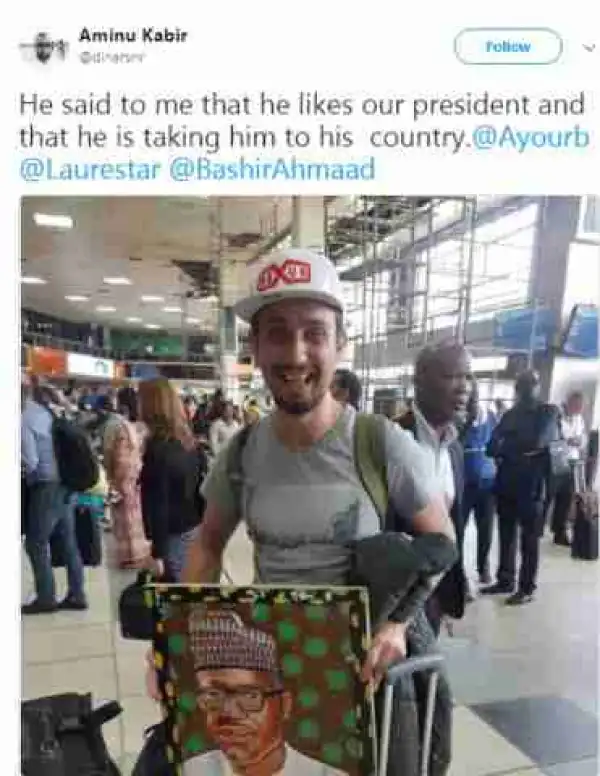 " I Like Him ":- White Man Pictured With A Portrait Of Pres.Buhari At The Airport